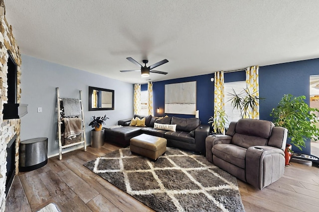 7720 Red Finch Ct NW, Albuquerque, NM 87114 - living area with wood-type flooring, a fireplace, a ceiling fan, and a textured ceiling