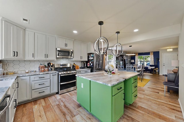 7720 Red Finch Ct NW, Albuquerque, NM 87114 - kitchen featuring appliances with stainless steel finishes, a kitchen island, green cabinetry, light wood-style flooring, and recessed lighting