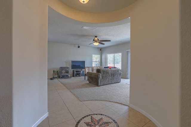 3929 Las Colinas Ave, Rio Rancho, NM 87124 - living area with light tile patterned flooring, a textured ceiling, light colored carpet, baseboards, and a ceiling fan