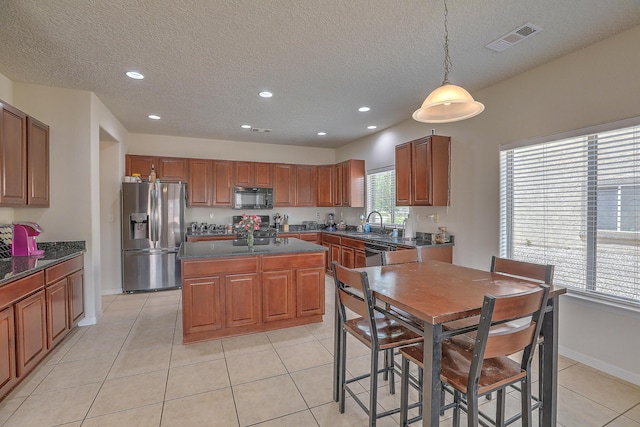 3929 Las Colinas Ave, Rio Rancho, NM 87124 - kitchen with stainless steel appliances, a center island, recessed lighting, a textured ceiling, and baseboards