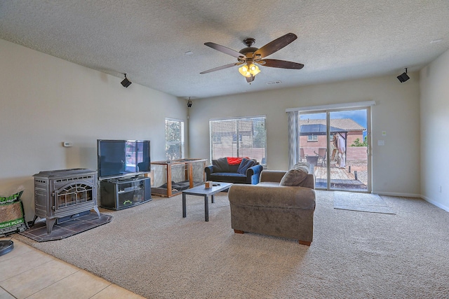 3929 Las Colinas Ave, Rio Rancho, NM 87124 - living room featuring a wood stove, carpet flooring, a textured ceiling, and ceiling fan
