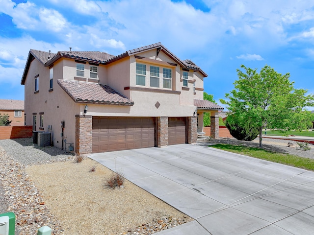 3929 Las Colinas Ave, Rio Rancho, NM 87124 - mediterranean / spanish-style home featuring stucco siding, an attached garage, a tiled roof, stone siding, and driveway