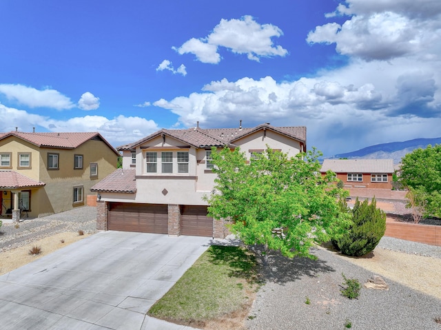 3929 Las Colinas Ave, Rio Rancho, NM 87124 - view of front of house with a garage, driveway, stucco siding, a mountain view, and a tile roof