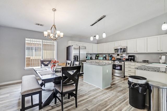 6605 Country Knoll Ct NW, Albuquerque, NM 87114 - kitchen featuring appliances with stainless steel finishes, a sink, a chandelier, light wood-style flooring, and a kitchen island