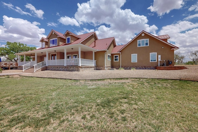 rear view of house with covered porch, metal roof, and a yard