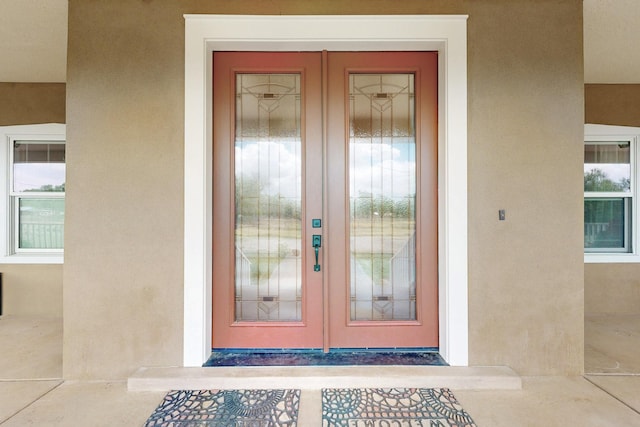 property entrance featuring french doors and stucco siding