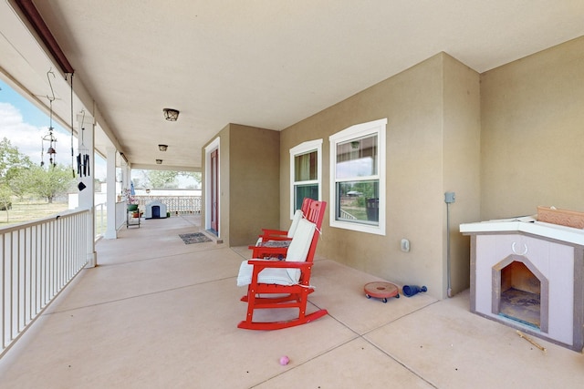view of patio with a fireplace and a porch