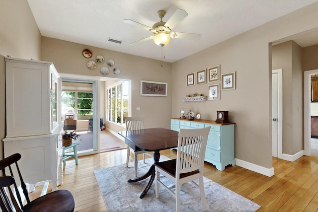 dining space with light wood finished floors, a ceiling fan, and baseboards
