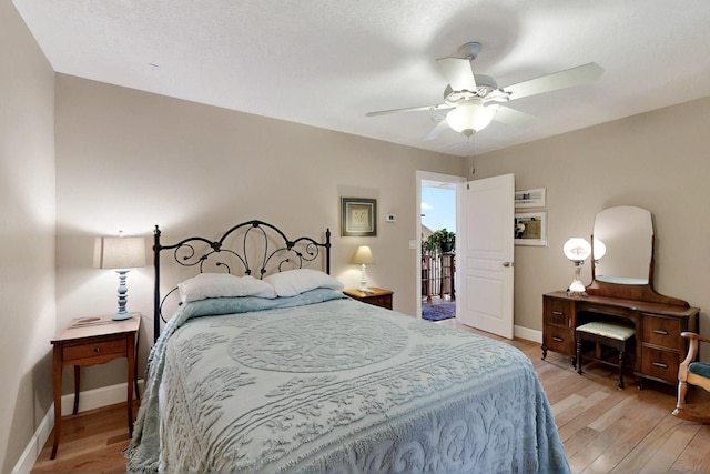 bedroom with light wood-style floors, baseboards, and a ceiling fan