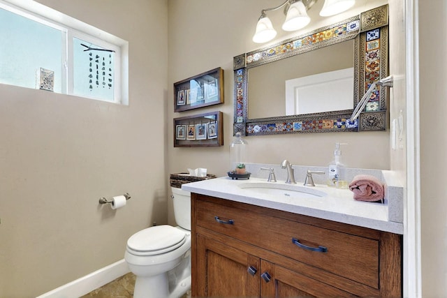 half bath with toilet, vanity, baseboards, and tile patterned flooring