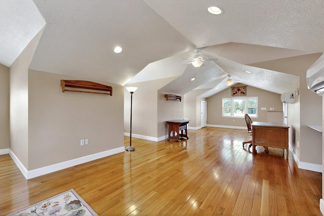 bonus room with vaulted ceiling, hardwood / wood-style flooring, baseboards, a ceiling fan, and a textured ceiling