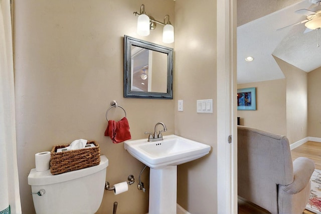 bathroom featuring toilet, a ceiling fan, baseboards, and a sink