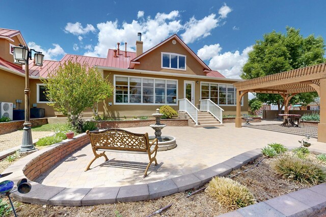 70 Sanchez Rd, Belen, NM 87002 - back of property featuring stucco siding, a standing seam roof, metal roof, and a pergola