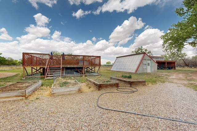 view of yard featuring a vegetable garden, an outbuilding, and fence
