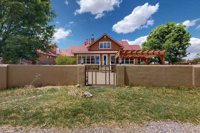 back of house with a gate, a pergola, stucco siding, and metal roof