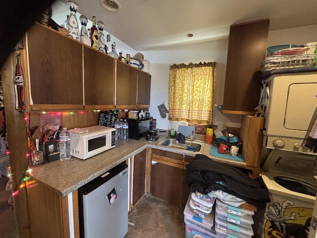 1816 Isleta Blvd SW, Albuquerque, NM 87105 - kitchen with white microwave, fridge, estacked washer and dryer, tile patterned flooring, and black microwave