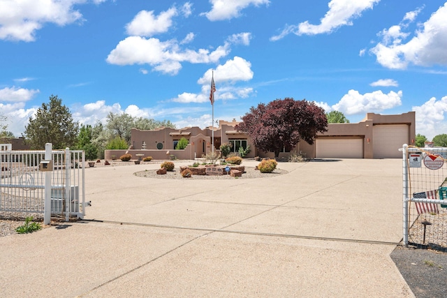 12 Blueberry Ln, Los Lunas, NM 87031 - southwest-style home featuring a gate, driveway, stucco siding, an attached garage, and fence