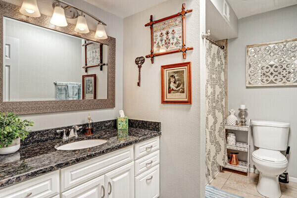 6400 Torreon Dr NE, Albuquerque, NM 87109 - full bath featuring toilet, vanity, baseboards, and tile patterned flooring