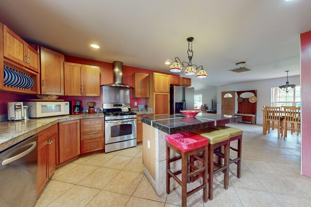 5 Francisco Rd, Cedar Crest, NM 87008 - kitchen with appliances with stainless steel finishes, wall chimney range hood, tile counters, light tile patterned floors, and a kitchen island
