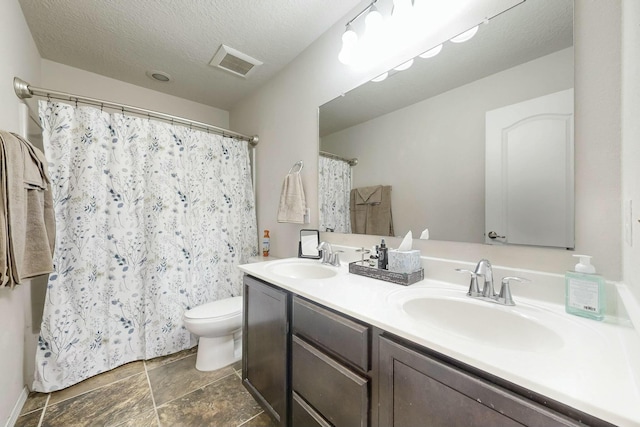9631 Iron Rock Dr NW, Albuquerque, NM 87114 - full bathroom featuring double vanity, curtained shower, and a textured ceiling