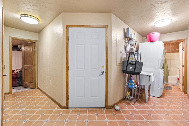 160 Black Bear Rd, Ramah, NM 87321 - basement with stacked washer / dryer, a textured wall, and a textured ceiling