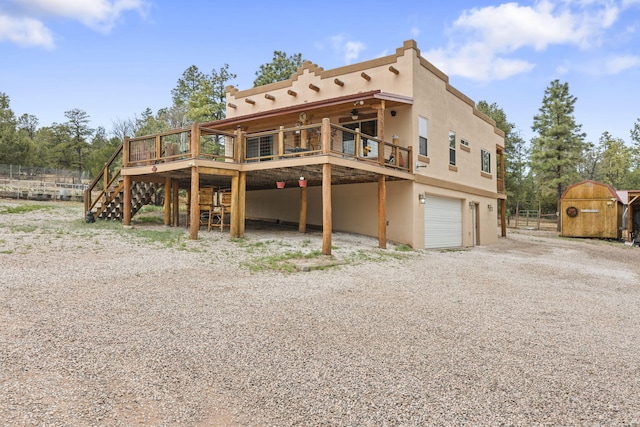 160 Black Bear Rd, Ramah, NM 87321 - back of house with gravel driveway, a garage, stairs, a wooden deck, and stucco siding
