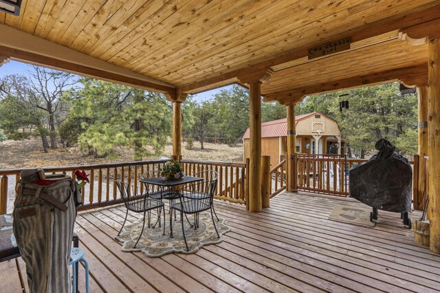 160 Black Bear Rd, Ramah, NM 87321 - wooden deck featuring outdoor dining space, an outbuilding, view of wooded area, and grilling area