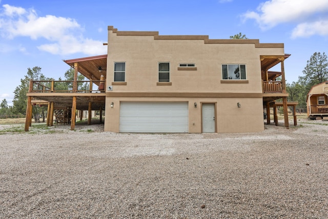 160 Black Bear Rd, Ramah, NM 87321 - back of house with gravel driveway, a deck, an attached garage, and a ceiling fan
