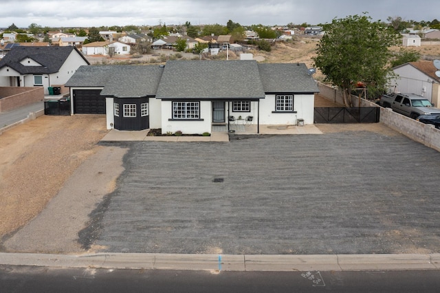 404 Pecos Loop SE, Rio Rancho, NM 87124 - view of front of property with roof with shingles, an attached garage, a residential view, driveway, and stucco siding