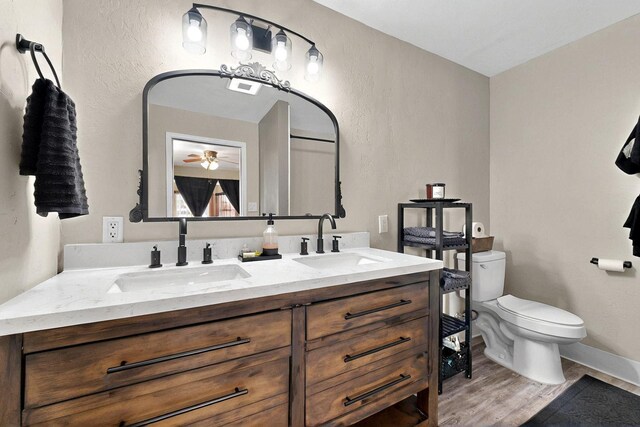 404 Pecos Loop SE, Rio Rancho, NM 87124 - full bathroom featuring toilet, wood finished floors, ceiling fan, double vanity, and baseboards