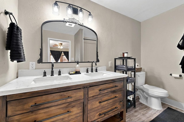 404 Pecos Loop SE, Rio Rancho, NM 87124 - full bathroom featuring double vanity, wood finished floors, ceiling fan, toilet, and baseboards