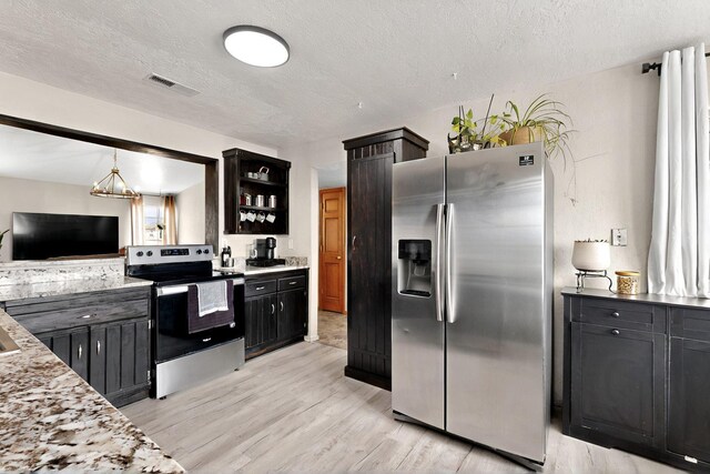 404 Pecos Loop SE, Rio Rancho, NM 87124 - kitchen featuring stainless steel appliances, light wood-style flooring, dark cabinetry, open shelves, and a textured ceiling