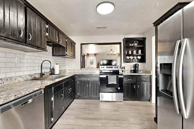 404 Pecos Loop SE, Rio Rancho, NM 87124 - kitchen with appliances with stainless steel finishes, a sink, light wood-style floors, tasteful backsplash, and open shelves