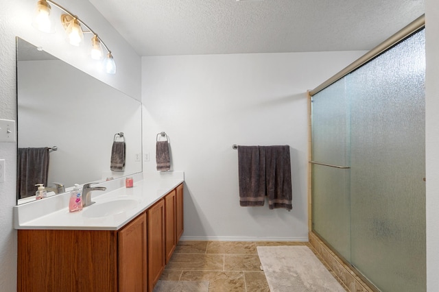 3772 Havasu Falls St NE, Rio Rancho, NM 87144 - bathroom with vanity, a shower with shower door, a textured ceiling, and baseboards