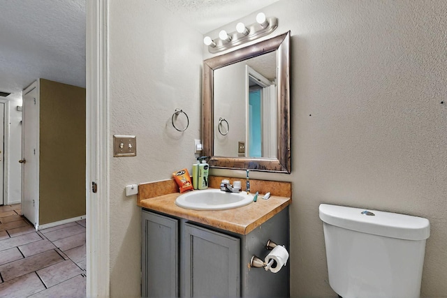 8912 Silverado Ave SW, Albuquerque, NM 87121 - half bathroom with vanity, toilet, tile patterned flooring, and a textured ceiling