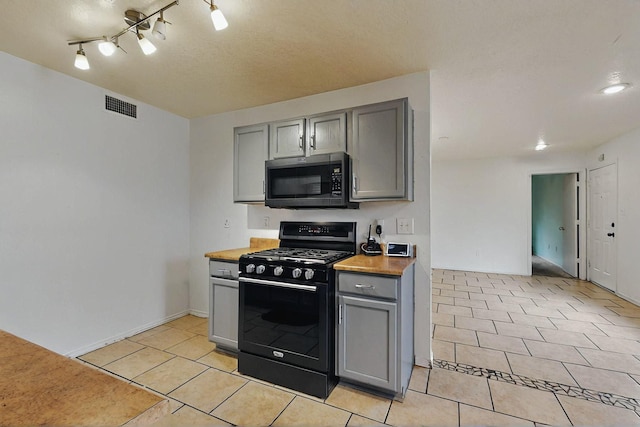 8912 Silverado Ave SW, Albuquerque, NM 87121 - kitchen with black range with gas cooktop, gray cabinetry, and light tile patterned flooring