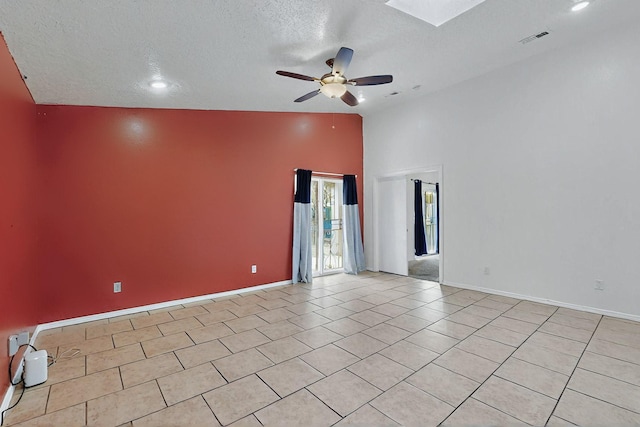 8912 Silverado Ave SW, Albuquerque, NM 87121 - spare room featuring a ceiling fan, a textured ceiling, light tile patterned floors, baseboards, and a skylight