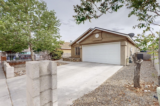8912 Silverado Ave SW, Albuquerque, NM 87121 - view of front of home with fence, stucco siding, concrete driveway, an attached garage, and central air condition unit