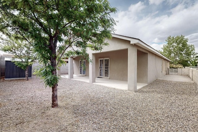 8912 Silverado Ave SW, Albuquerque, NM 87121 - rear view of property featuring stucco siding, a patio, and fence