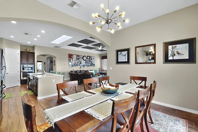 7241 Aldan Dr NE, Rio Rancho, NM 87144 - dining area with arched walkways, a chandelier, light wood-style flooring, recessed lighting, and baseboards