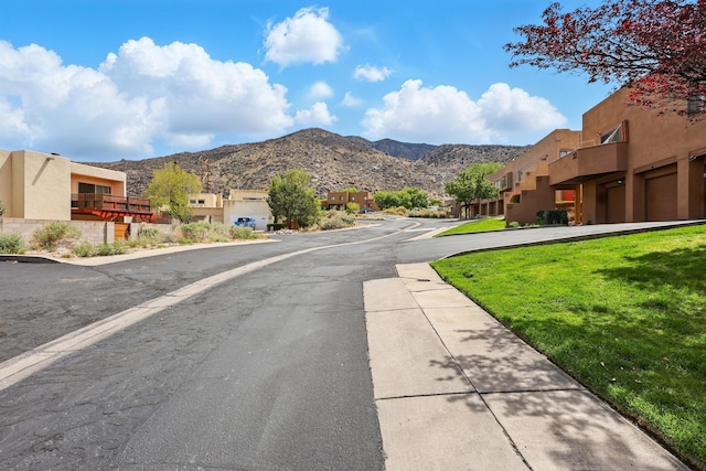view of asphalt road featuring a residential view and a mountain view