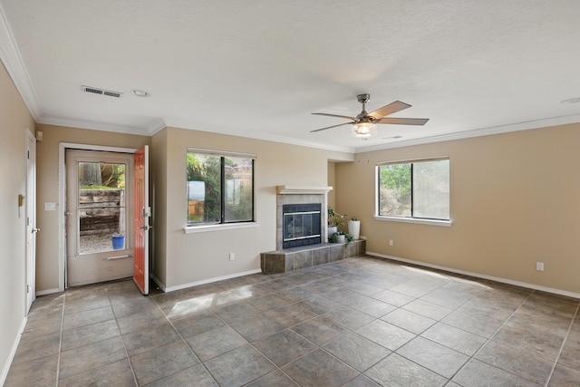 unfurnished living room with a ceiling fan, crown molding, baseboards, a tile fireplace, and tile patterned floors