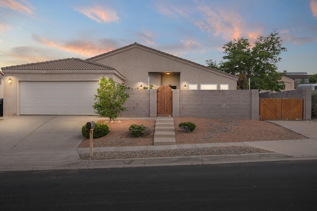 4700 Crestridge Ave NW, Albuquerque, NM 87114 - view of front of house with stucco siding, concrete driveway, a gate, a garage, and a tiled roof