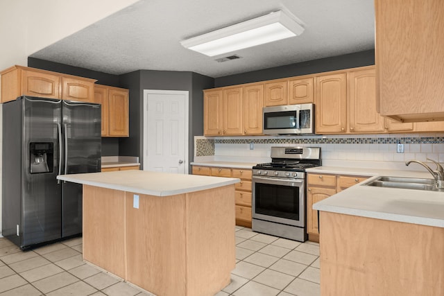 4700 Crestridge Ave NW, Albuquerque, NM 87114 - kitchen featuring stainless steel appliances, a sink, light tile patterned floors, and a center island