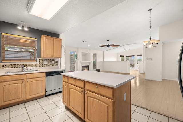 4700 Crestridge Ave NW, Albuquerque, NM 87114 - kitchen with dishwasher, a sink, a ceiling fan, a kitchen island, and a warm lit fireplace