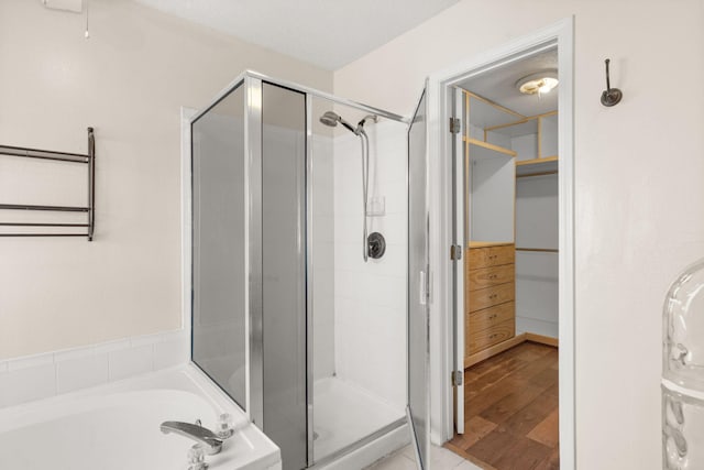 4700 Crestridge Ave NW, Albuquerque, NM 87114 - bathroom with a shower stall, a garden tub, wood finished floors, and a spacious closet