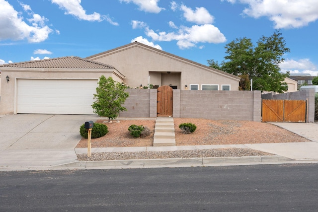 4700 Crestridge Ave NW, Albuquerque, NM 87114 - view of front of home with a gate, stucco siding, a garage, driveway, and a tile roof