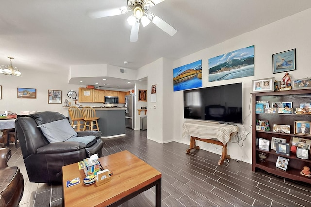 living room with a ceiling fan, wood tiled floors, baseboards, a chandelier, and recessed lighting