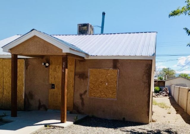 376 58th St NW, Albuquerque, NM 87105 - rear view of house with fence, metal roof, and stucco siding