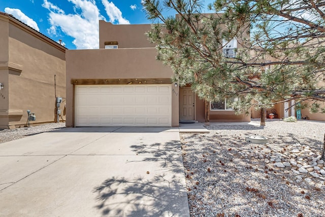 2512 Sarita Ave NW, Albuquerque, NM 87104 - pueblo-style home featuring stucco siding, concrete driveway, and a garage